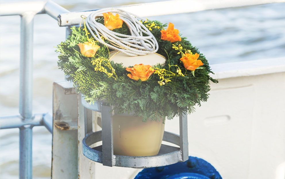 Blumenkranz mit grünen Blättern und orangenen Blumen