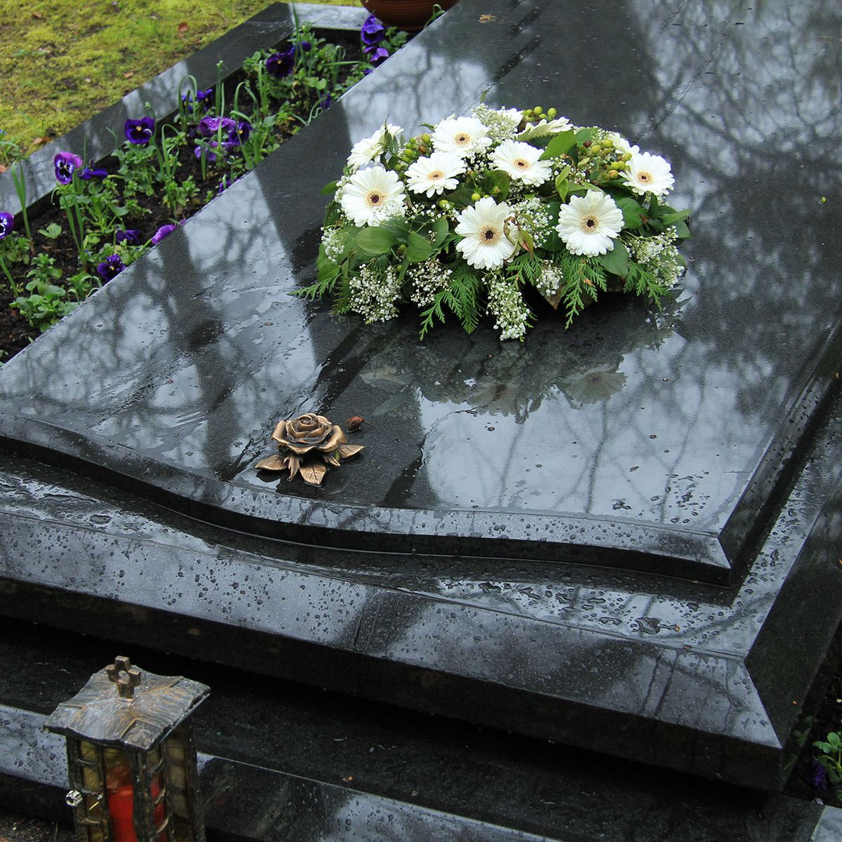 Schwarzer Grabstein mit Blumen