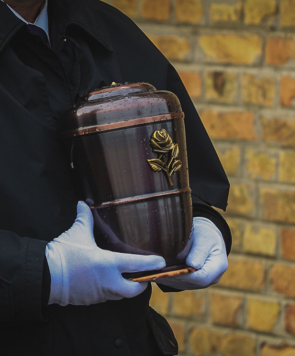 Eine Person trägt eine Urne